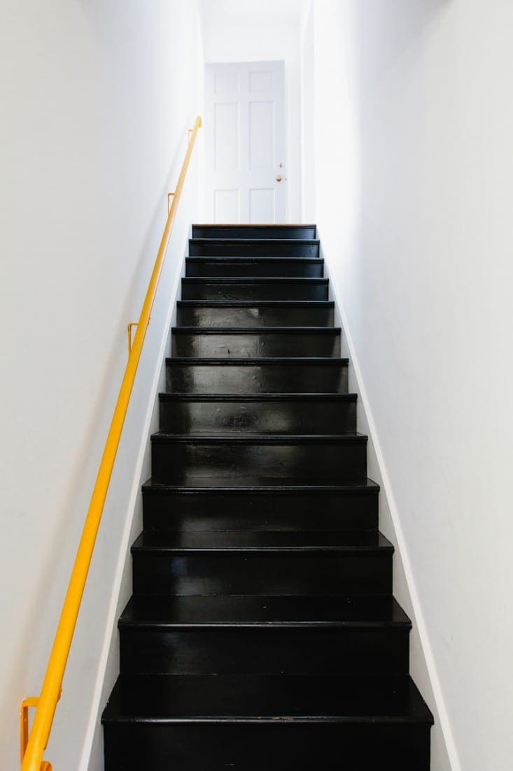 Zwarte trap met gele reling